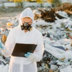 Researcher looking at plastic landfill analyzing environmental pollution level